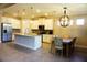 Spacious kitchen featuring granite counters, stainless appliances, white cabinetry, and a breakfast table with stylish chandelier at 136 Positano Trl, Nokomis, FL 34275