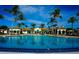 A community pool with a large pool deck with lounge seating, surrounded by palm trees and lush landscaping at 136 Positano Trl, Nokomis, FL 34275