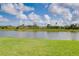 Lush green lawn meeting a serene pond view, perfect for nature lovers at 13634 Vancanza Dr, Venice, FL 34293
