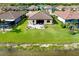 Aerial view of the home's backyard, featuring a well-maintained lawn and beautiful lake views at 13634 Vancanza Dr, Venice, FL 34293