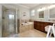 Lovely bathroom featuring a walk-in shower, soaking tub, and and sinks at 13634 Vancanza Dr, Venice, FL 34293