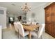 The dining room features a wooden table with seating for six and an open view to the kitchen area at 13634 Vancanza Dr, Venice, FL 34293