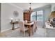 The dining room features a wooden table with seating for six, a stylish chandelier, and neutral decor at 13634 Vancanza Dr, Venice, FL 34293