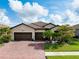 Charming home with a three car garage, well-manicured lawn, and lush landscaping at 13634 Vancanza Dr, Venice, FL 34293