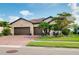 Charming home with a three car garage, lush landscaping, and a brick driveway at 13634 Vancanza Dr, Venice, FL 34293