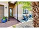 Charming outdoor seating area on the front porch with comfortable blue Adirondack chairs at 13634 Vancanza Dr, Venice, FL 34293