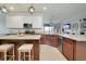 Open-concept kitchen featuring an island with bar seating, granite countertops, and stainless steel appliances at 13634 Vancanza Dr, Venice, FL 34293