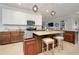 Spacious kitchen featuring an island with bar stools, granite countertops, and modern stainless steel appliances at 13634 Vancanza Dr, Venice, FL 34293