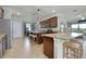 Open kitchen with granite countertops, dark wood cabinets, stainless steel appliances, and bar seating at 13634 Vancanza Dr, Venice, FL 34293