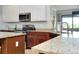 This kitchen features granite countertops, a stainless steel microwave, and a view into the living area at 13634 Vancanza Dr, Venice, FL 34293
