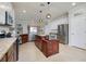 Bright kitchen with granite counters, stainless steel appliances, island, and white cabinets at 13634 Vancanza Dr, Venice, FL 34293