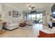The living room features a sectional sofa, a ceiling fan, and sliding glass doors to the outdoor space at 13634 Vancanza Dr, Venice, FL 34293