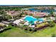Aerial view of resort-style pool area with palm trees, lounge chairs, and lush landscaping at 13634 Vancanza Dr, Venice, FL 34293