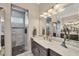 Luxurious bathroom featuring dual vanities, a stylish walk-in shower with marble countertops, and designer accents at 14398 Fort Worth Cir, Port Charlotte, FL 33981