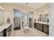 Elegant bathroom with dual vanities, decorative lighting, and walk-in shower featuring gray tile and black pebble floor at 14398 Fort Worth Cir, Port Charlotte, FL 33981