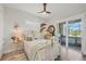 Bright bedroom featuring a white wrought iron bed, neutral tones, and lanai access at 14398 Fort Worth Cir, Port Charlotte, FL 33981