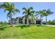Beautiful home featuring lush green lawn and mature palm trees at 14398 Fort Worth Cir, Port Charlotte, FL 33981