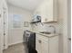 Well-organized laundry room features modern appliances, counter space, and stylish tile backsplash at 14398 Fort Worth Cir, Port Charlotte, FL 33981