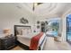 Bright main bedroom featuring a ceiling fan, sliding doors to the pool, and stylish decor at 14398 Fort Worth Cir, Port Charlotte, FL 33981