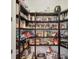 Walk-in pantry with dark wood shelves, neatly stocked with a variety of food and household items at 14398 Fort Worth Cir, Port Charlotte, FL 33981