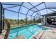 The enclosed pool area offers stunning views of the serene waterway and tropical landscaping at 14398 Fort Worth Cir, Port Charlotte, FL 33981