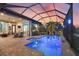 Relaxing screened pool area with outdoor dining and lounging spaces, overlooking a serene waterfront view at sunset at 14398 Fort Worth Cir, Port Charlotte, FL 33981