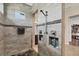 Walk-in shower showcasing gray tile walls, a black pebble floor, and a stylish shower system with built-in shelves at 14398 Fort Worth Cir, Port Charlotte, FL 33981