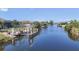 Scenic waterfront view featuring a private dock and canal access, surrounded by lush landscaping and clear blue skies at 14398 Fort Worth Cir, Port Charlotte, FL 33981