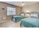 Cozy bedroom featuring twin beds with matching floral cushions, a ceiling fan, and a window with blinds at 1531 Placida Rd # 202 Building 9, Englewood, FL 34223