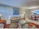Bright living room featuring a comfortable couch, colorful rug, and a decorative glass coffee table at 1531 Placida Rd # 202 Building 9, Englewood, FL 34223