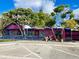 Bright pink restaurant exterior with blue accents, lush trees, and outdoor seating at 1531 Placida Rd # 202 Building 9, Englewood, FL 34223