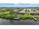 Aerial view of a luxurious waterfront home with a private dock and serene lake views at 15336 Spanish Point Dr, Port Charlotte, FL 33981