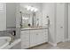 Bathroom vanity with granite countertop, white cabinets, and decorative mirror at 15336 Spanish Point Dr, Port Charlotte, FL 33981