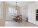 Cozy dining area features a round wooden table, four chairs, and a decorative wood chandelier at 15336 Spanish Point Dr, Port Charlotte, FL 33981