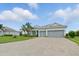 Charming single-story home with a three-car garage, beautiful landscaping, and a paver driveway at 15336 Spanish Point Dr, Port Charlotte, FL 33981