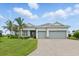 Charming single-story home with a three-car garage, beautiful landscaping, and a paver driveway at 15336 Spanish Point Dr, Port Charlotte, FL 33981