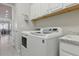 This bright laundry room contains a washer and dryer, a sink, lots of storage and natural light at 15336 Spanish Point Dr, Port Charlotte, FL 33981