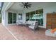 A covered patio with comfortable seating, a ceiling fan, and large sliding glass doors into the home at 15336 Spanish Point Dr, Port Charlotte, FL 33981