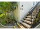 Exterior staircase with lush tropical plants providing an inviting entryway at 1555 Tarpon Center Dr # G 235, Venice, FL 34285