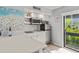 Modern kitchen with stainless steel appliances, white cabinets, and a sliding glass door at 1555 Tarpon Center Dr # G 235, Venice, FL 34285