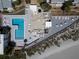 Aerial view of a community pool with lounge chairs and tables, next to the beach at 1555 Tarpon Center Dr # G 235, Venice, FL 34285