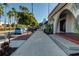 A view of a clean city sidewalk bordered by palms and buildings in a sunny environment at 1555 Tarpon Center Dr # G 235, Venice, FL 34285