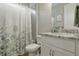 Cozy bathroom featuring shower with floral curtain and granite sink at 15963 Crofton Springs Way, Port Charlotte, FL 33953