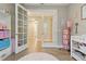 Open french doors lead to Bedroom with stylish decor and wood floors at 15963 Crofton Springs Way, Port Charlotte, FL 33953