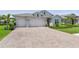 Charming single-Gathering home featuring a brick driveway, a two-car garage, and a well-manicured lawn with mature landscaping at 15963 Crofton Springs Way, Port Charlotte, FL 33953