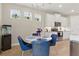 Open floor plan features the kitchen with white cabinets, stainless steel appliances, island, breakfast bar, and dining area at 15963 Crofton Springs Way, Port Charlotte, FL 33953