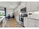 Bright kitchen features white cabinets, stainless steel appliances, and a cozy breakfast nook with a view at 15963 Crofton Springs Way, Port Charlotte, FL 33953