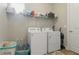 Well lit laundry room with washer, dryer, storage, and wood floors at 15963 Crofton Springs Way, Port Charlotte, FL 33953
