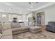 Spacious living room with a large sectional couch, an open floor plan with a kitchen, and an archway to a hallway at 15963 Crofton Springs Way, Port Charlotte, FL 33953