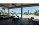 Inviting covered outdoor seating area overlooking a luxurious swimming pool with palm trees at 15963 Crofton Springs Way, Port Charlotte, FL 33953